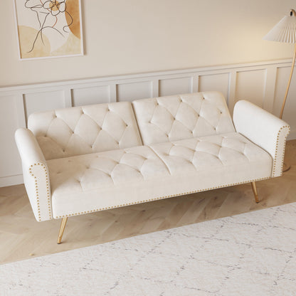 Un divano letto lungo 69,7 pollici rivestito in tessuto di velluto beige, con finiture a borchie e accompagnato da un cuscino coordinato.