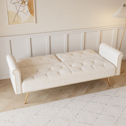 Un divano letto lungo 69,7 pollici rivestito in tessuto di velluto beige, con finiture a borchie e accompagnato da un cuscino coordinato.