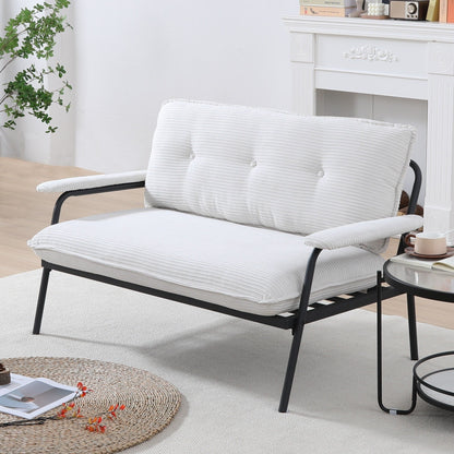 Il divano beige da 53 pollici offre una disposizione spaziosa nel piccolo appartamento, gestendo facilmente vari scenari